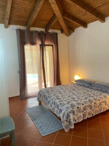 a bedroom with a bed and a window at Villa Olivastro Piscina privata in Stintino