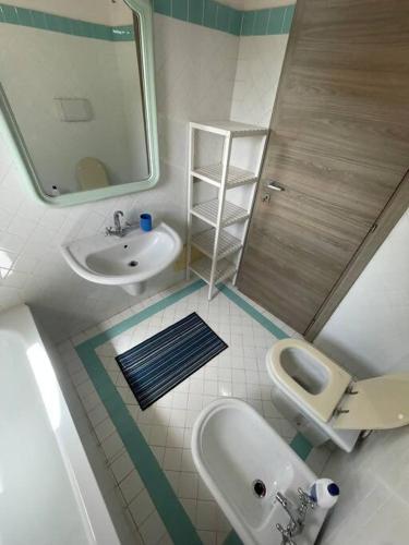 a bathroom with a sink and a toilet and a mirror at Villa Olivastro Piscina privata in Stintino