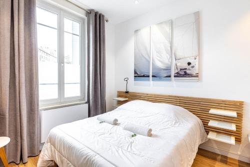 a white bedroom with a bed and a window at GuestReady - Cosy studio in Saint-Maur-des-Fossés in Joinville-le-Pont