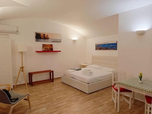 um quarto com uma cama, uma mesa e cadeiras em Alex Guest House. em Nápoles