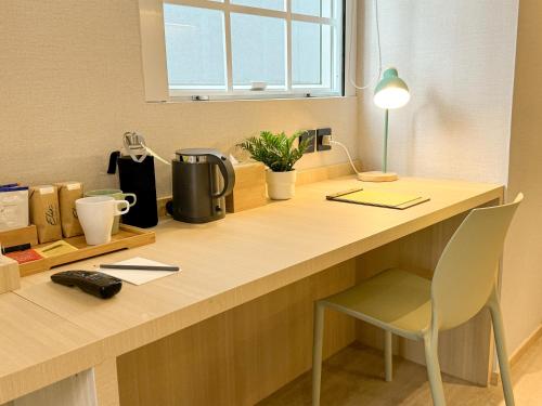 a desk with a chair and a lamp on it at Urbanwood Hung Hom in Hong Kong