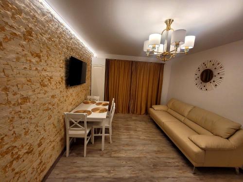 - un salon avec un canapé et une table dans l'établissement R&R Apartament, à Ocna-Mureşului