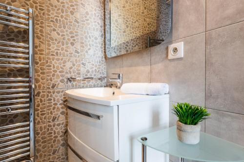 ein Bad mit einem Waschbecken und einem Spiegel in der Unterkunft Freres PradignacLAT1101 in Cannes