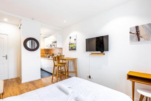 a bedroom with a bed and a kitchen with a table at GuestReady - Cosy studio in Saint-Maur-des-Fossés in Joinville-le-Pont