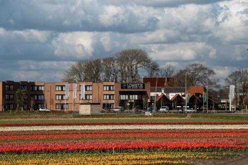 a field of tulips in front of a building at Hotel Lowietje Lisse - Keukenhof in Lisse