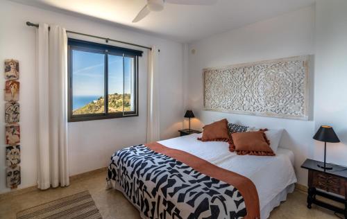 a bedroom with a bed and a large window at Campo Agave B&B in Sayalonga