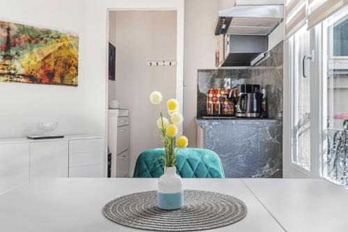 un vase avec des fleurs sur une table dans une cuisine dans l'établissement Heimat, à Paris