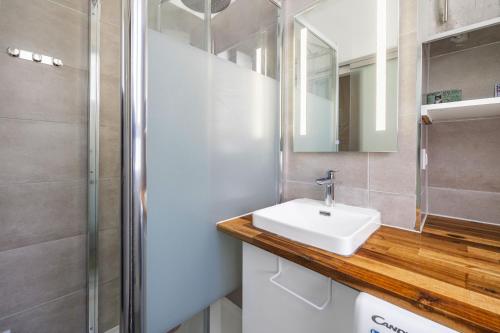 une salle de bain avec un lavabo et une douche dans l'établissement Heimat, à Paris