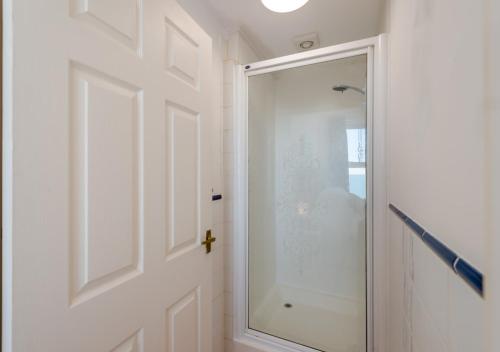 a glass shower door in a white bathroom at Coastal Nest - Hythe in Hythe