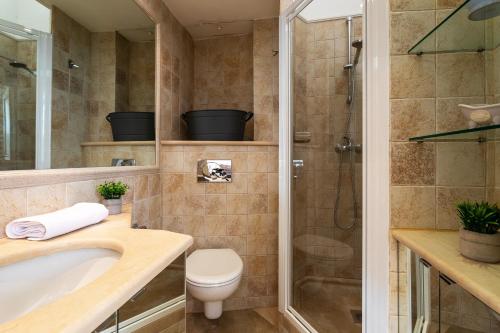 een badkamer met een douche, een toilet en een wastafel bij Frères Pradignac in Cannes