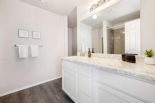a white bathroom with a large sink and a mirror at The Swift - 2 Mi from DT Fayetteville in Fayetteville