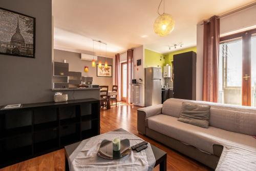 a living room with a couch and a kitchen at TURIN CENTER whit PRIVATE PARKING in Turin
