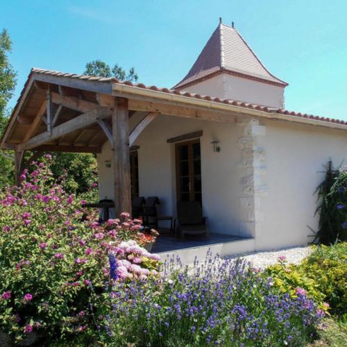 une petite maison blanche avec une pergola en bois dans l'établissement Domaine du Lac, Eymet, à Eymet