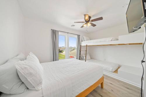 1 Schlafzimmer mit 2 Etagenbetten und einem Deckenventilator in der Unterkunft Shore Break at CB - 1 Block to Beach Access in Carolina Beach