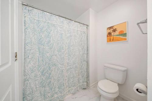 ein Badezimmer mit Toilette und Duschvorhang in der Unterkunft Shore Break at CB - 1 Block to Beach Access in Carolina Beach