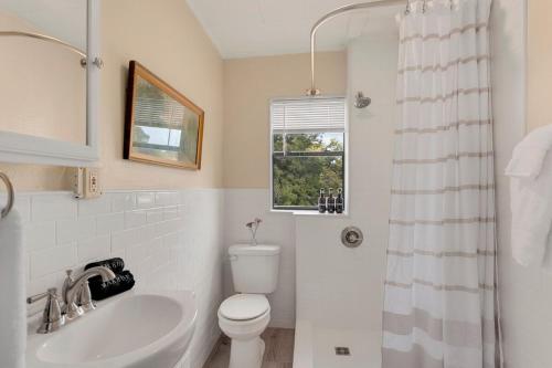a bathroom with a sink and a toilet and a window at The Wildflower- Monthly Rental - Walk Everywhere in Fayetteville