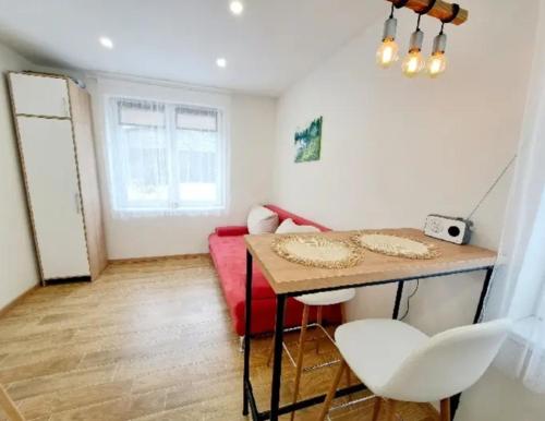 - un salon avec une table et un canapé rouge dans l'établissement Apartment Iskernik II. - High Tatras, à Vysoké Tatry