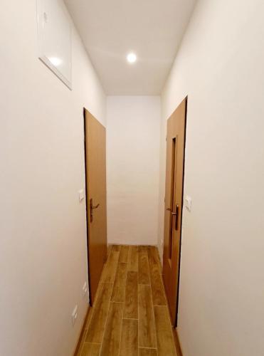 un couloir vide avec deux portes et du parquet dans l'établissement Apartment Iskernik II. - High Tatras, à Vysoké Tatry