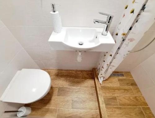 La salle de bains est pourvue d'un lavabo blanc et de toilettes. dans l'établissement Apartment Iskernik II. - High Tatras, à Vysoké Tatry
