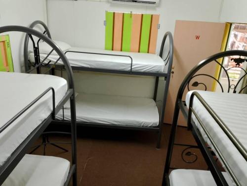 a room with three bunk beds and a chair at seaview hostel in George Town