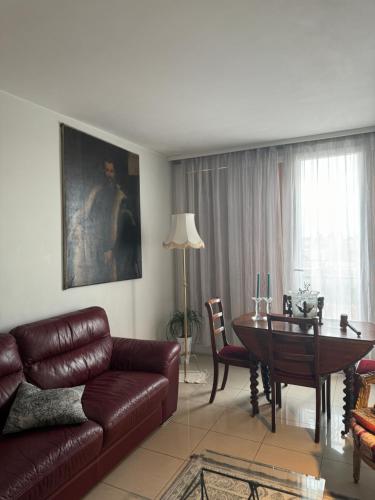 - un salon avec un canapé et une table à manger dans l'établissement Joli appartement avec vue sur la Tour Eiffel, à Villejuif