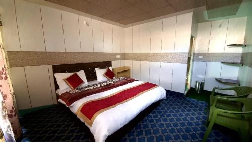 een slaapkamer met een groot bed met rode kussens bij Milam Cottage in Leh