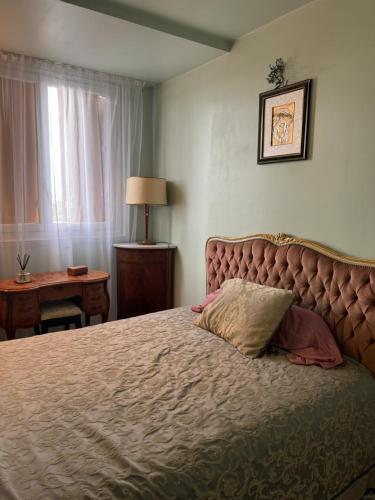 - une chambre avec un grand lit et un oreiller dans l'établissement Joli appartement avec vue sur la Tour Eiffel, à Villejuif