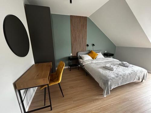 1 dormitorio con cama, escritorio y mesa en Apartamenty Parkowa - Kamień Śląski, en Kamień Śląski