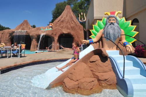 a little girl is climbing down a water slide at a water park at Atlantis Family Waterpark Hotel, an Ascend Collection Hotel in Wisconsin Dells