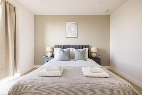 een slaapkamer met een groot bed met 2 kussens bij The Wembley Apartment in Londen