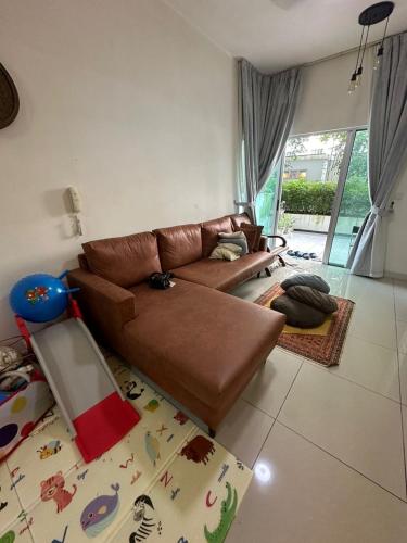 sala de estar con sofá de cuero marrón en Savanna Southville City - D1 Level 5, en Kampong Tangkas
