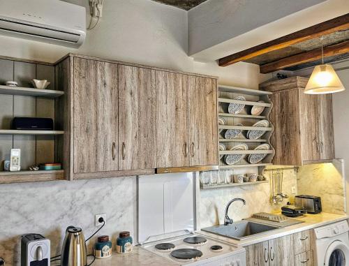 a kitchen with wooden cabinets and a sink at Sea-View Rooftop Terrace Studio in Pánormos
