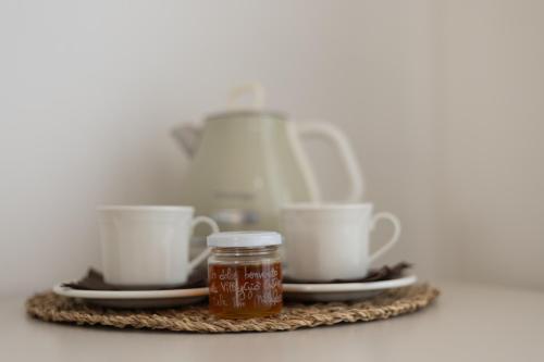 a tray of tea cups and a jar of honey at Le Casette di Giò in Monteodorisio