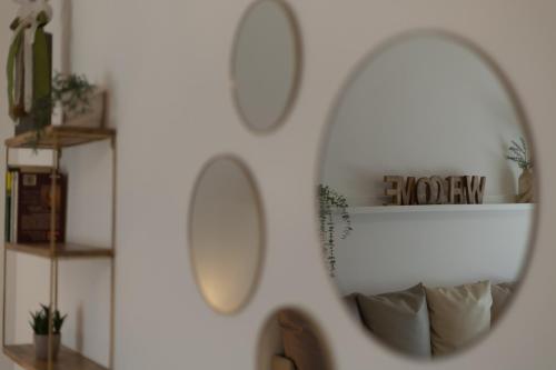 a mirror hanging on a white wall with shelves at Le Casette di Giò in Monteodorisio