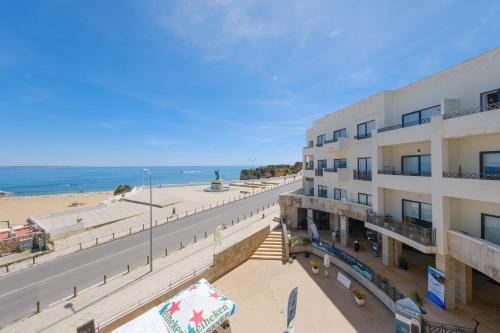 an apartment building with the beach in the background at Fábrica da Ribeira 55 by Destination Algarve in Lagos