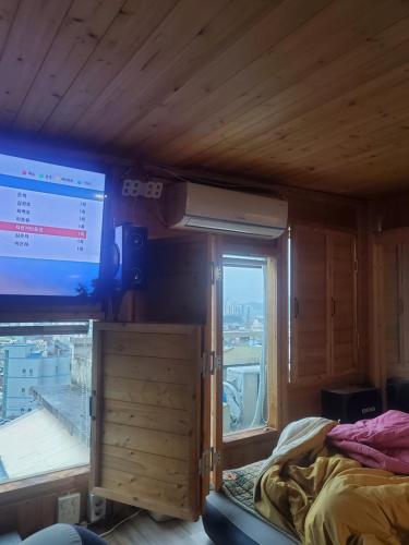 Zimmer mit einem Bett und einem großen Fenster in der Unterkunft Sky Karaoke in Busan