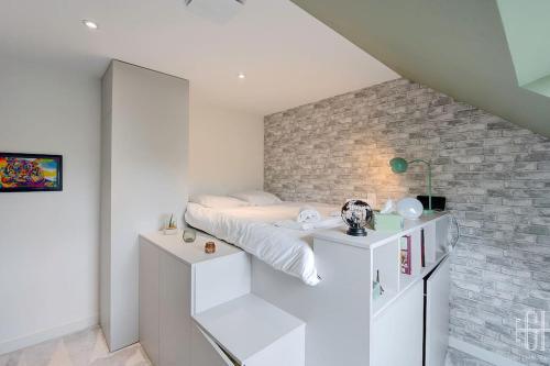 a bedroom with a bed and a brick wall at Casa Simone / Bords De Loire in Tours