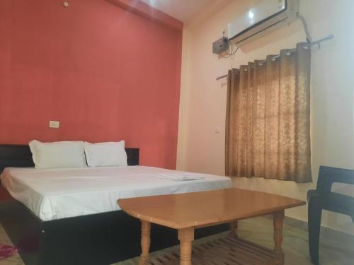Kleines Zimmer mit einem Bett und einem Tisch in der Unterkunft Sky Inn paying guest house in Varanasi