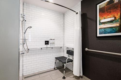 a bathroom with a shower with a chair in it at The Southlake Hotel in Southlake