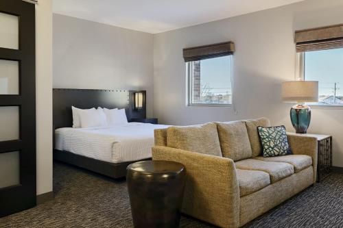 a hotel room with a bed and a couch at The Southlake Hotel in Southlake