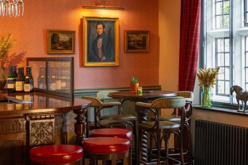 a bar with stools and a table in a restaurant at Stone House Hotel in Hawes