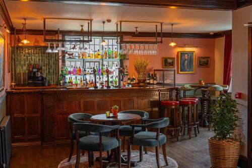 a bar with tables and chairs in a restaurant at Stone House Hotel in Hawes