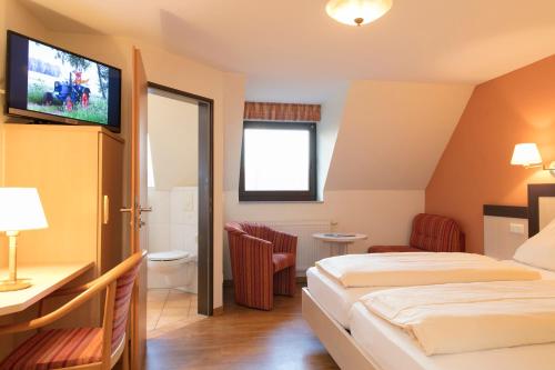 a hotel room with two beds and a flat screen tv at Landhuus Laurenz in Am Berge
