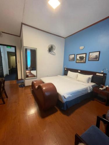 um quarto com uma cama grande e uma parede azul em A25 Hotel - 80 Mai Hắc Đế em Hanói