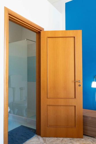 a wooden door in a room with a blue wall at B&B Longobardi in Trani