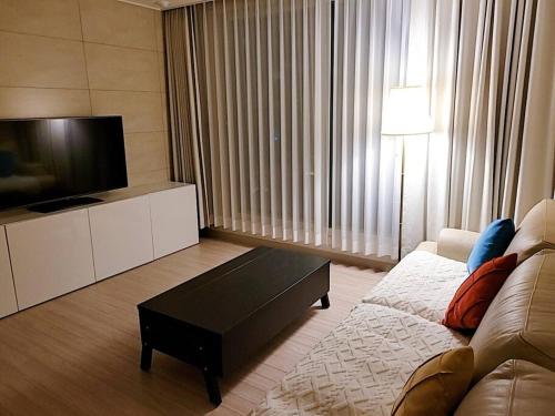 a living room with a couch and a flat screen tv at Emotion-고층뷰, 3룸, 화2 신축, 건조기, 세탁기, 이마트2분, 별내역3분, 출장 및 장기숙박 추천 in Namyangju