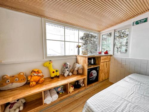 a bedroom with a bed and a shelf with stuffed animals at La Casa Di Dicembre 35A Nhà Chung in Hanoi