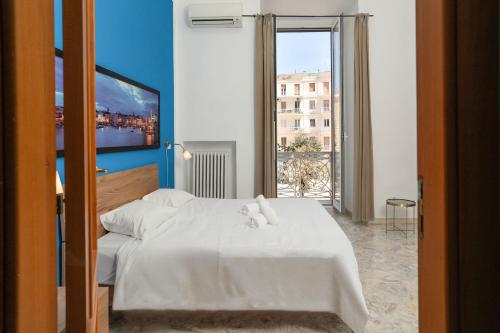 a bedroom with a white bed and a large window at B&B Longobardi in Trani