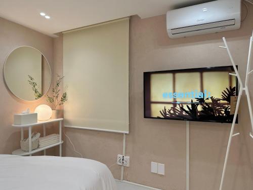 een slaapkamer met een bed en een tv aan de muur bij hoho house - double twin room in Busan