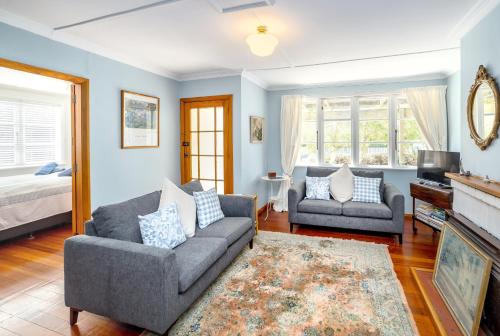 un salon avec deux canapés et une cheminée dans l'établissement Strasbourge Cottage, à Martinborough